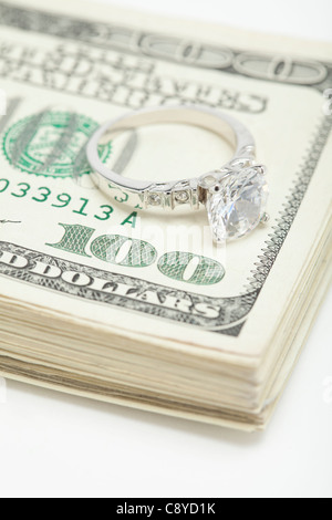 Anello in argento sul mazzetto di banconote di dollari, studio shot Foto Stock