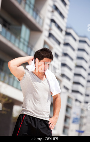 Atleta uomo stanco dopo una lunga esecuzione evento di sport nella città Foto Stock