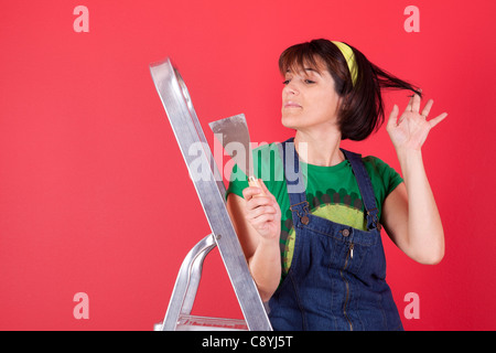 Bella donna con guardando la sua riflessione su una spatola Foto Stock