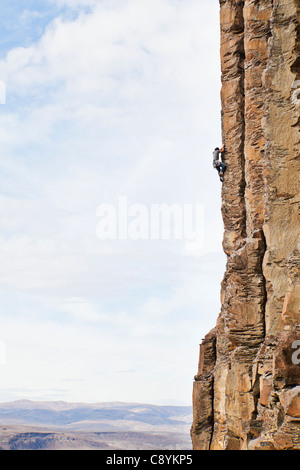 Un uomo scalata di un basalto roccia nel centro di stato di Washington, USA. Foto Stock