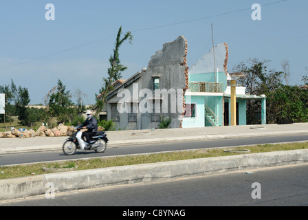 Asia, Vietnam, nr. Hoi An. Lungo la strada costiera tra Hoi An e Da Nang, le case sono state tagliate a metà per fare spazio per il ne... Foto Stock