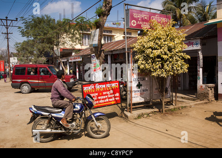 India, Assam, Majuli Island, villaggio Garamur bazaar, uomo arrivando alla clinica su motociclo Foto Stock