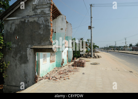 Asia, Vietnam, nr. Hoi An. Lungo la strada costiera tra Hoi An e Da Nang, le case sono state tagliate a metà per fare spazio per il ne... Foto Stock