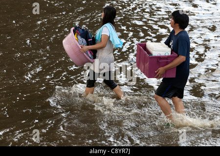 I rifugiati guadare attraverso l'acqua di inondazione in Bangkok city centre, Thailandia Foto Stock