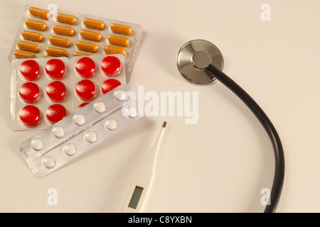 Pillole colorate con uno stetoscopio su un tavolo Foto Stock
