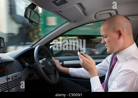 Uomo che utilizza il telefono cellulare durante la guida di auto in autostrada Foto Stock