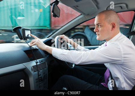 Uomo con navigatore satellitare GPS durante la guida di auto in autostrada Foto Stock