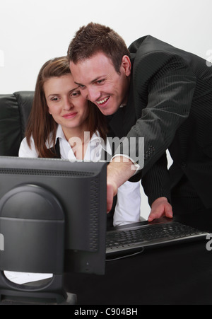 Happpy giovani businesspersons giovane lavorando insieme su un computer. Foto Stock