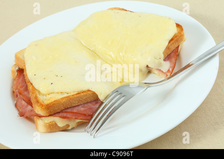 Croque monsieur, un tradizionale francese di prosciutto e formaggio toastie condito con salsa besciamella e formaggio fuso con una forchetta. Foto Stock