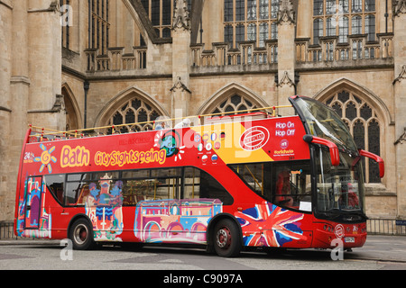 I turisti city tour a sommità aperta bus turistico in attesa al di fuori della vecchia abbazia. Bagno, Somerset, Inghilterra, Regno Unito, Gran Bretagna Foto Stock