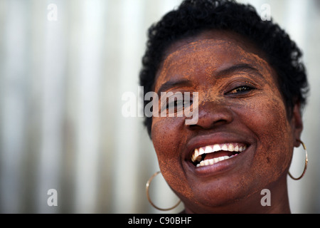 Un malgascio donna nella sua quarantina indossando il tradizionale pittura del viso sorrisi apertamente in Hell-Ville, Nosy Be (Nossi-bé), Madagascar Foto Stock