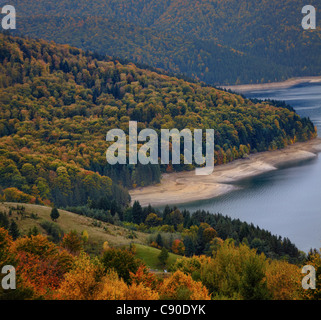 Il fogliame di autunno sul lato di Izvorul Muntelui lago in Romania. Foto Stock