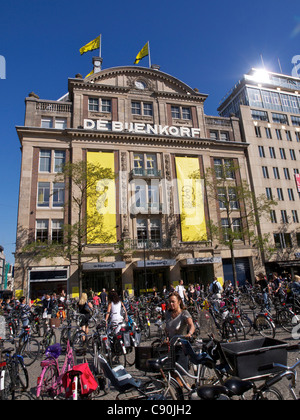 Il famoso Bijenkorf Luxury department store in piazza Dam, Amsterdam Paesi Bassi, con un milione di biciclette parcheggiate davanti. Foto Stock