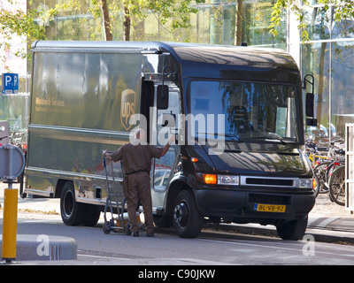 UPS l uomo con il suo camion consegnare i pacchi ad Amsterdam la Zuid-come il quartiere finanziario Foto Stock