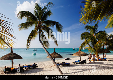 Le palme e la gente sulla spiaggia di Beachcomber Hotel Paradis &amp;amp;amp; Golf Club, Mauritius, Africa Foto Stock