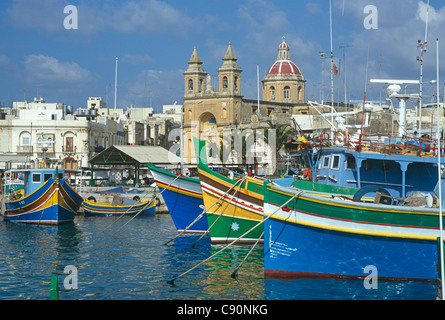 Marsaxlokk è un tradizionale villaggio di pescatori sulla costa sud-orientale. Ci sono barche tradizionali o luzzu ormeggiata in Foto Stock