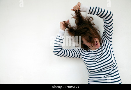 Donna tirando i suoi capelli. Foto Stock