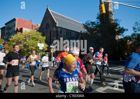 Guide di scorrimento in gara scendono Fifth Avenue attraverso Harlem nel annuale quarantaduesima ING New York City Marathon Foto Stock