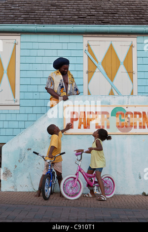 I Paesi Bassi, Oranjestad, Sint Eustatius Isola, olandese dei Caraibi. Rastafari uomo che parla con i suoi figli, un ragazzo e una ragazza. Foto Stock