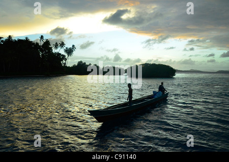 Gli uomini di Papua in barca da pesca al tramonto, Raja Ampat isole vicino Papua occidentale, in Indonesia nel triangolo di corallo, Oceano Pacifico. Foto Stock