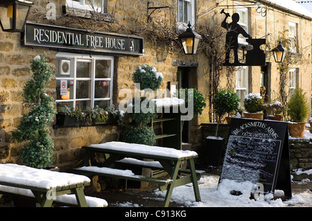 Una pesante caduta di neve si aggiunge al fascino del Fabbro di braccia in Lastingham sulla North Yorkshire Moors, Inghilterra. Foto Stock