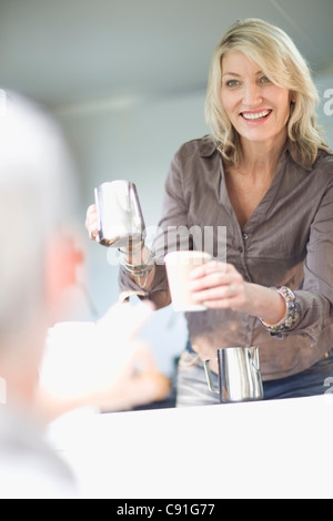 Donna che serve caffè in food cart Foto Stock