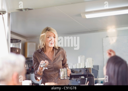 Donna che serve caffè in food cart Foto Stock