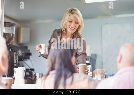 Donna che serve caffè in food cart Foto Stock