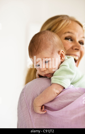 Madre cullano neonato sulla spalla Foto Stock