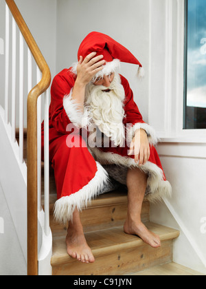 Uomo in Santa Claus suit seduti sui gradini Foto Stock