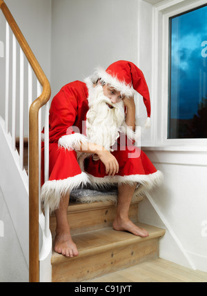 Uomo in Santa Claus suit seduti sui gradini Foto Stock