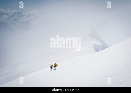 Gli sciatori sciare fino alla vetta del Monte Gerdine nel Tordrillo Mountains, inverno in Alaska centromeridionale Foto Stock