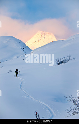Gli sciatori sci in salita al di sopra di Thompson passa su ragazze montagna vicino a Valdez, inverno in Alaska centromeridionale Foto Stock