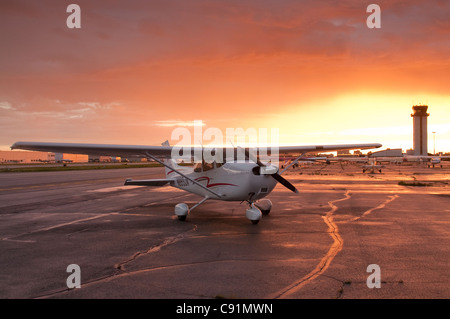 Il sole tramonta dietro un Cessna 172 a Merrill Field di Anchorage, centromeridionale Alaska, estate Foto Stock