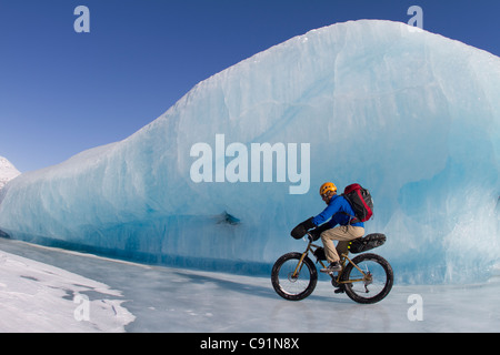 L'uomo Fat Tire mountain bike su ghiaccio al ghiacciaio Knik, Chugach Mountains, centromeridionale Alaska, inverno Foto Stock