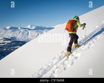 Donna salendo per una sci backcountry correre a vortici, Turnagain Pass, Kenai Mountains, centromeridionale Alaska, inverno Foto Stock