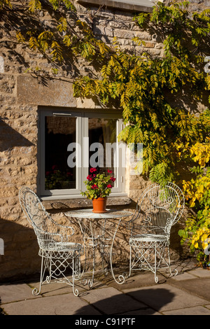 Metallo stile francese per esterno tavolo e sedie sul patio in pietra nel giardino inglese Foto Stock