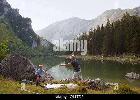 Padre e figlio pitching una tenda dal lago Foto Stock