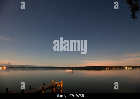 Dock di legno che si estendono nel lago ancora Foto Stock