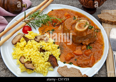 Ossobuco con funghi porcini risotto, servita sulla terrazza di una grotta in Ticino Foto Stock