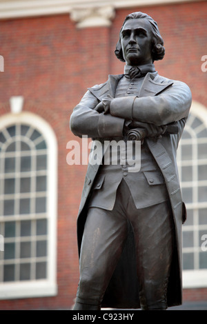 Una statua di Samuel Adams statista e Padre Fondatore sorge nella parte anteriore del Faneuil Hall dove la città di Boston incontro fu tenuto. Foto Stock