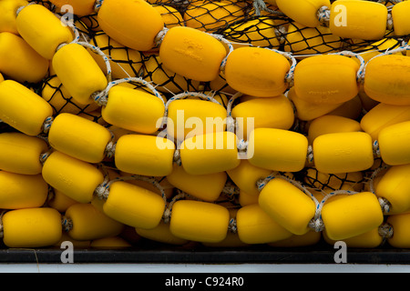 Di colore giallo brillante tappi e la pesca commerciale seine net impilati sul ponte di una nave in Auke Bay, vicino a Juneau, Alaska, estate Foto Stock