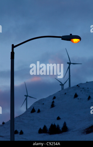 Lampione illumina calorosamente nel tardo pomeriggio con turbine eoliche sulla sommità del pilastro montagna dietro la città di Kodiak, Southwest Alaska Foto Stock