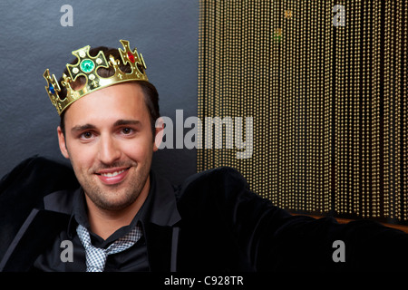 Uomo sorridente indossando la corona in plastica Foto Stock