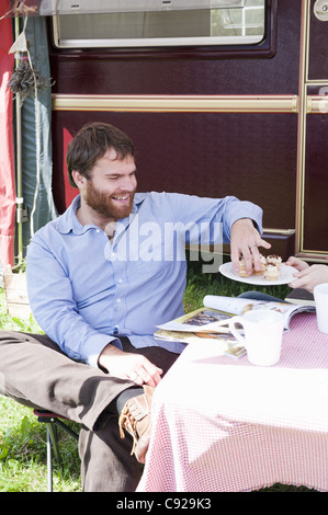 L'uomo fare picnic al di fuori del rimorchio Foto Stock