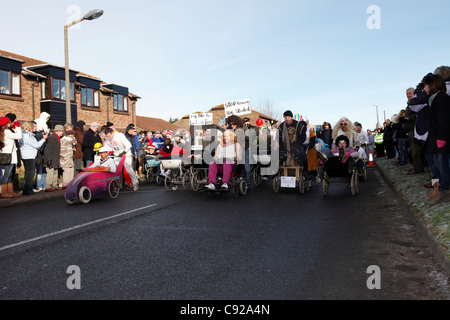 La stravagante Pagham annuale Pram gara disputata annualmente sul Boxing Day, 26 dic, nel villaggio di Pagham, West Sussex, in Inghilterra Foto Stock