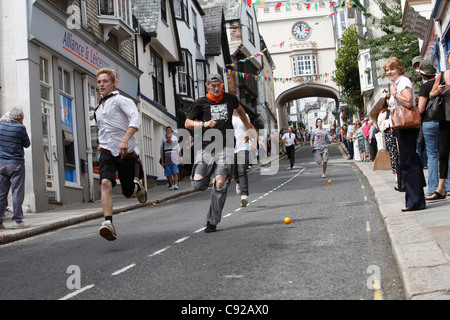 La stravagante a Totnes annuali gare di arancione, tenuto su un estate mattina dei giorni feriali su High Street a Totnes, Devon, Inghilterra Foto Stock