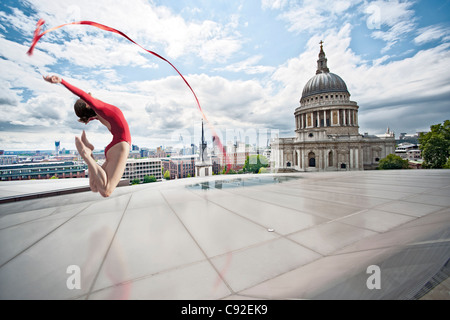 Ballerina con fiocco sul tetto urbano Foto Stock