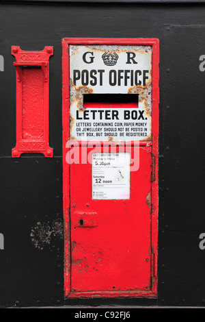 Vi è un tradizionale ferro verniciato rosso postbox nel muro di una casa in Hastings risalente al regno del re George V. Foto Stock