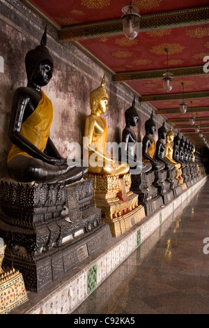 Nero e oro statue di Buddha seduto in una fila di Bangkok, Tailandia. Foto Stock